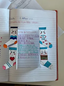 Pagina di un quaderno con una filastrocca e immagini di calzini colorati.